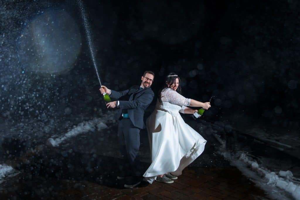 Couple swinging together on a rope swing at night in the rain