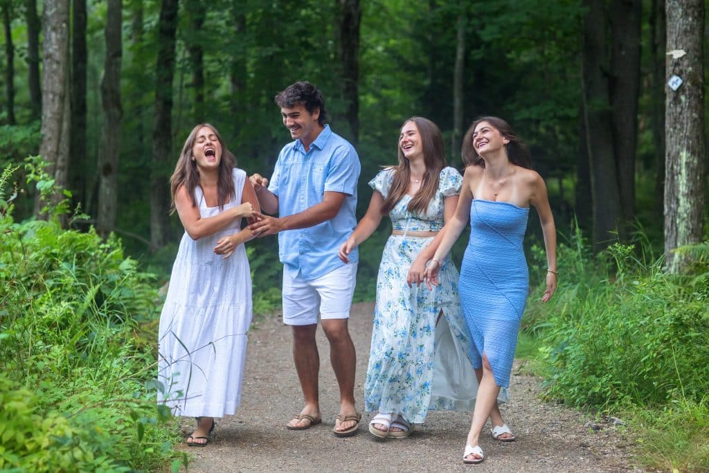 Family laughing and walking together along a wooded path